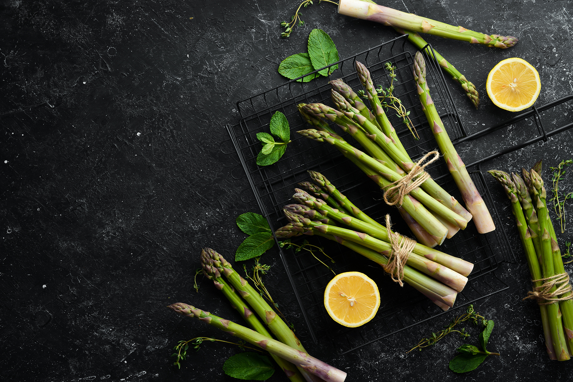Fresh green asparagus on a black stone background. Healthy food.
